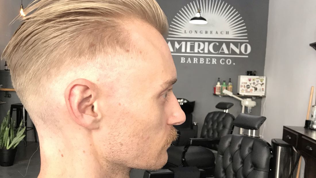 A slick back cut in front of the Americano logo wall