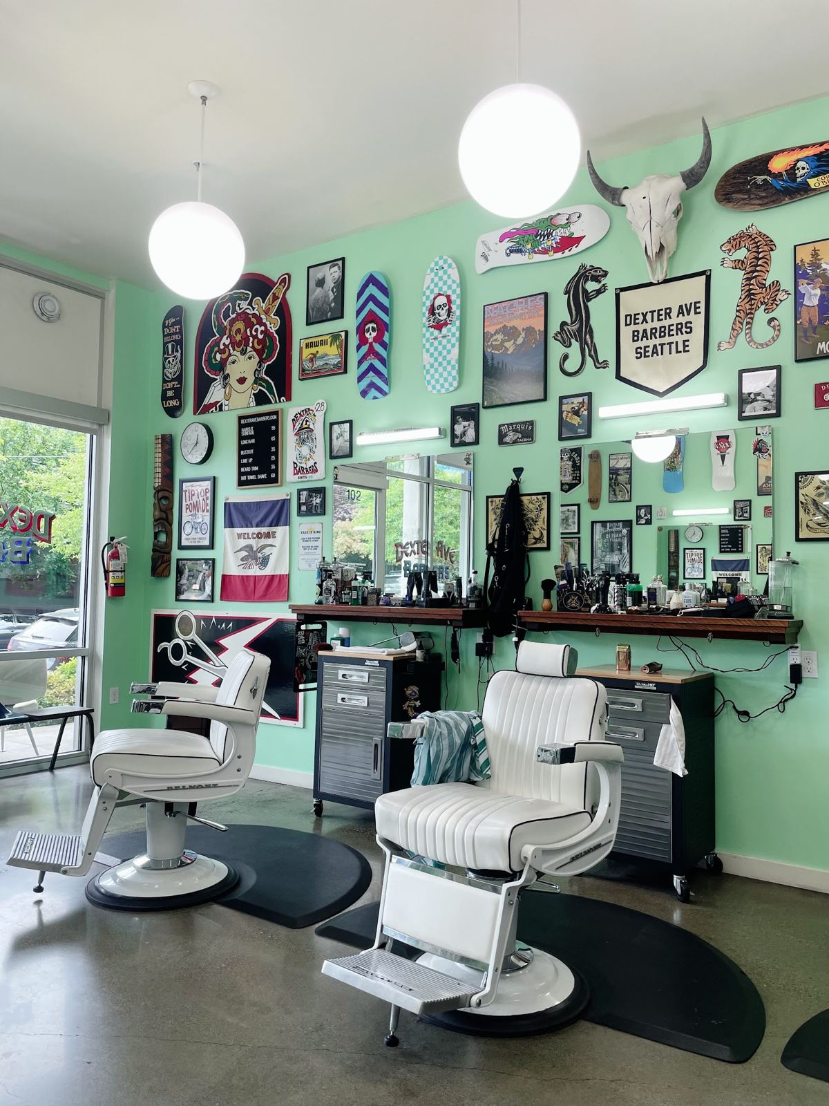 Inside Dexter Ave Barbers, vintage white chairs and walls of flash art