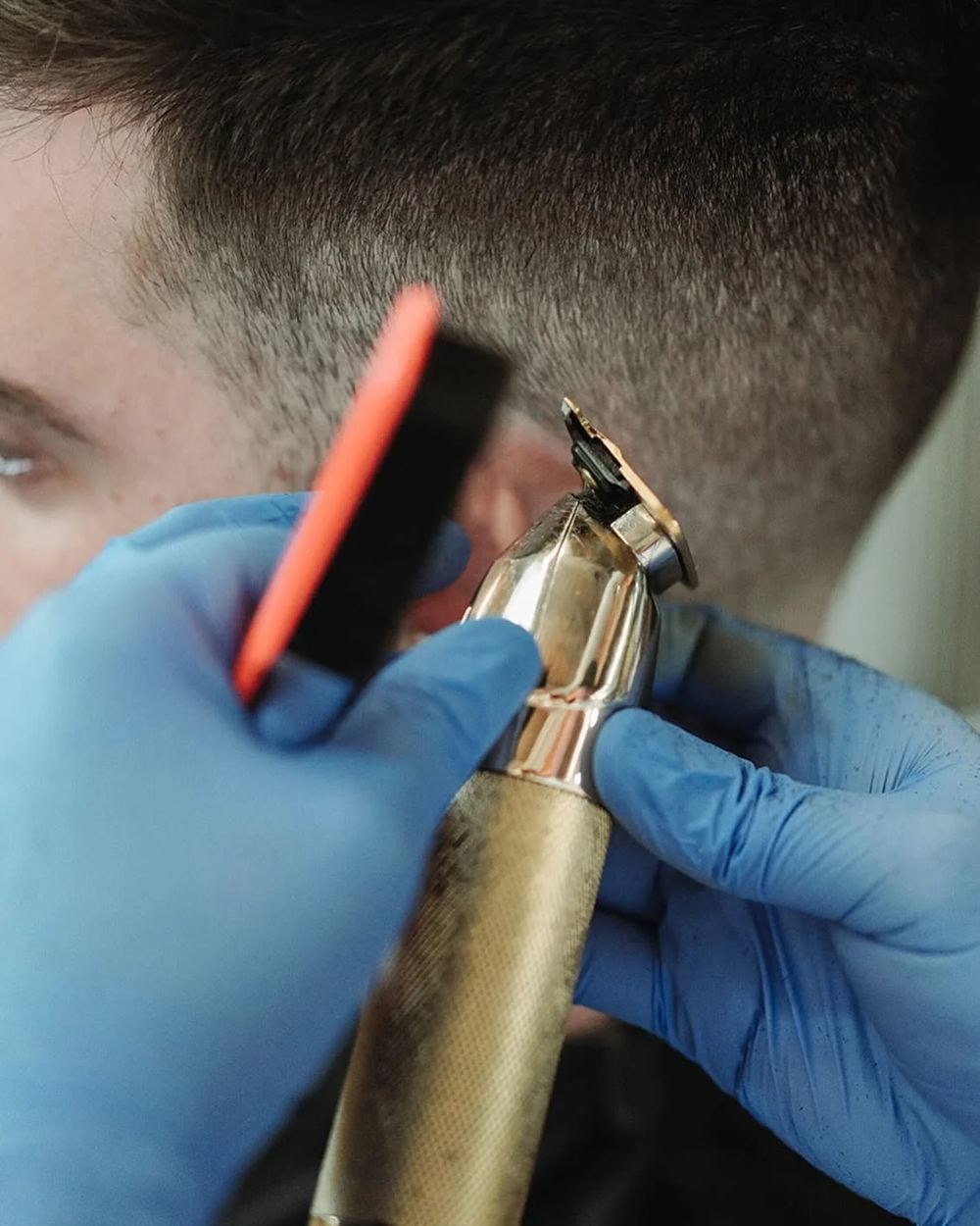 Gold clippers on a skin fade