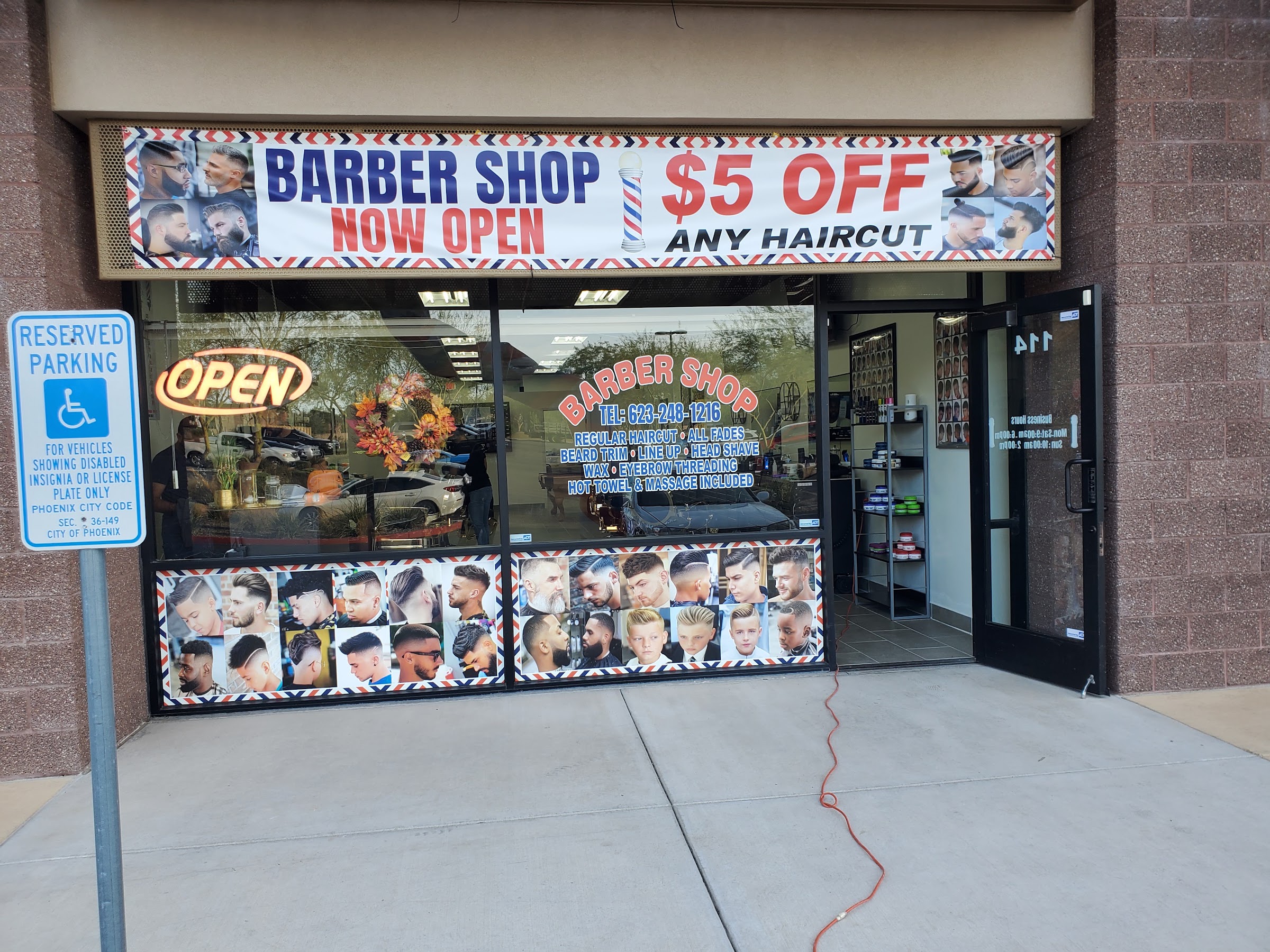 The Kingsman Barbershop storefront at suite 114 with the open sign lit