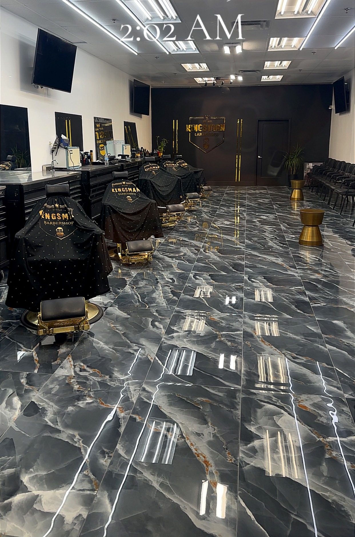 The remodeled Kingsman floor: black marble tile, gold stools and the gold logo wall