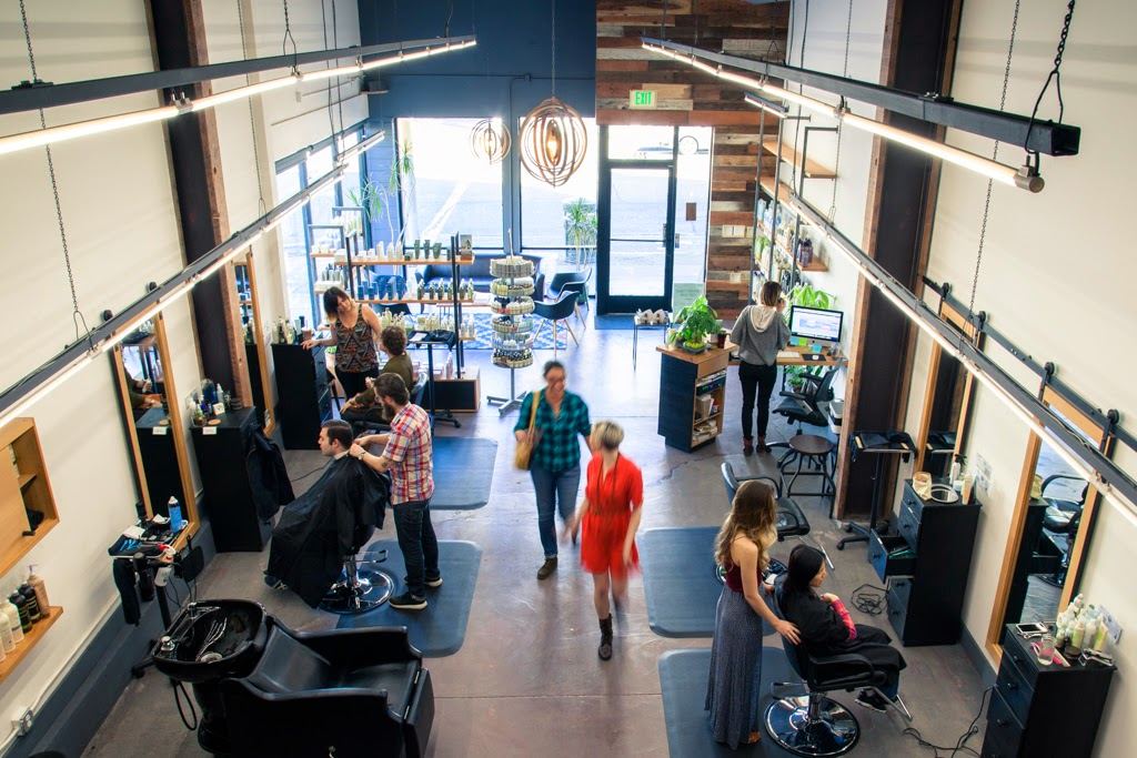 The salon floor with stations and wash chairs