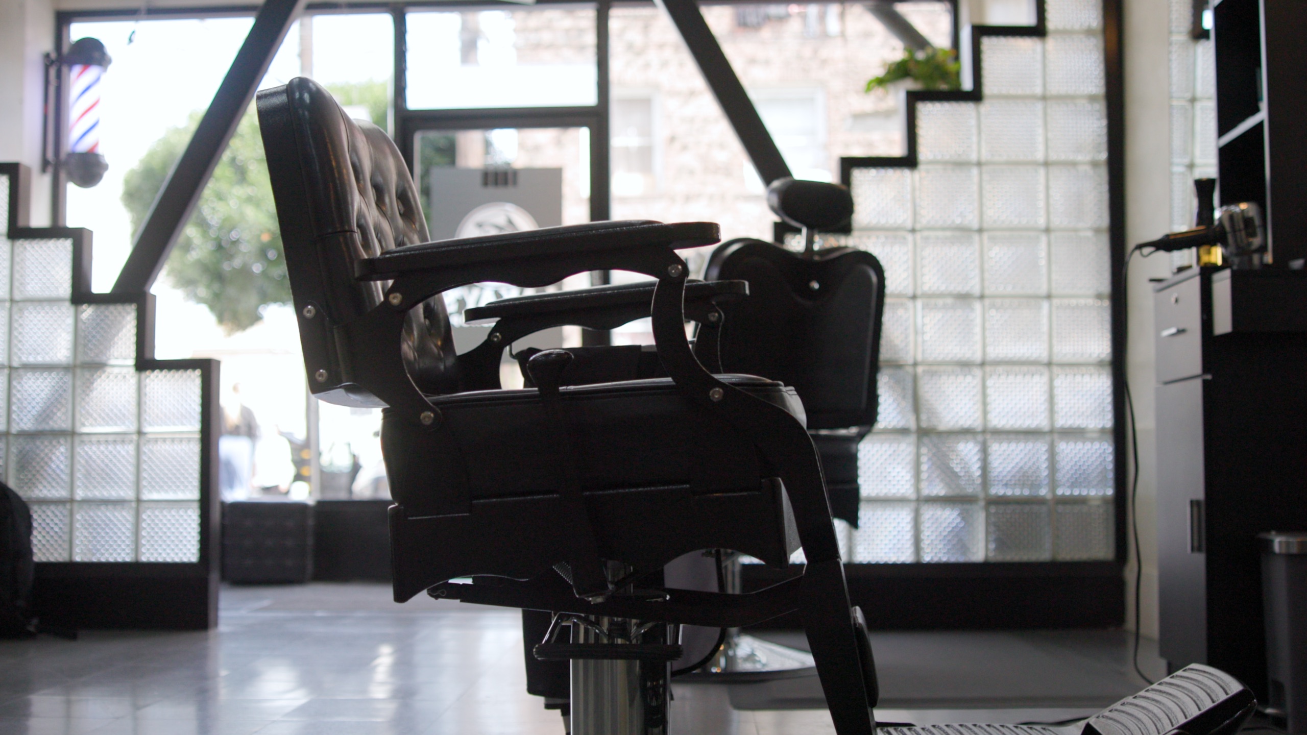 Vintage barber chairs at Lakay’s Barbershop with the barber pole in the Powell Street window