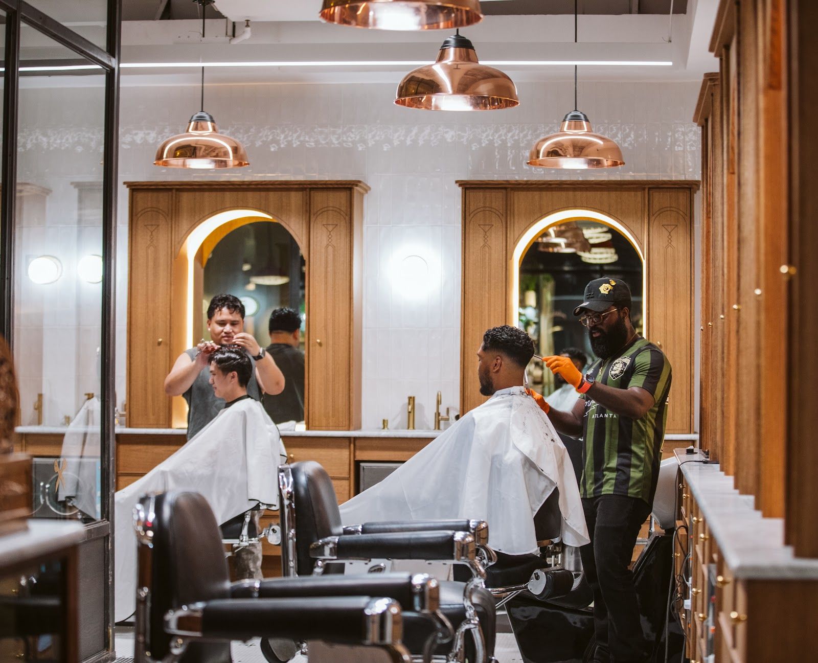 Barbers at work under the copper lamps at The Commodore, Ponce City Market