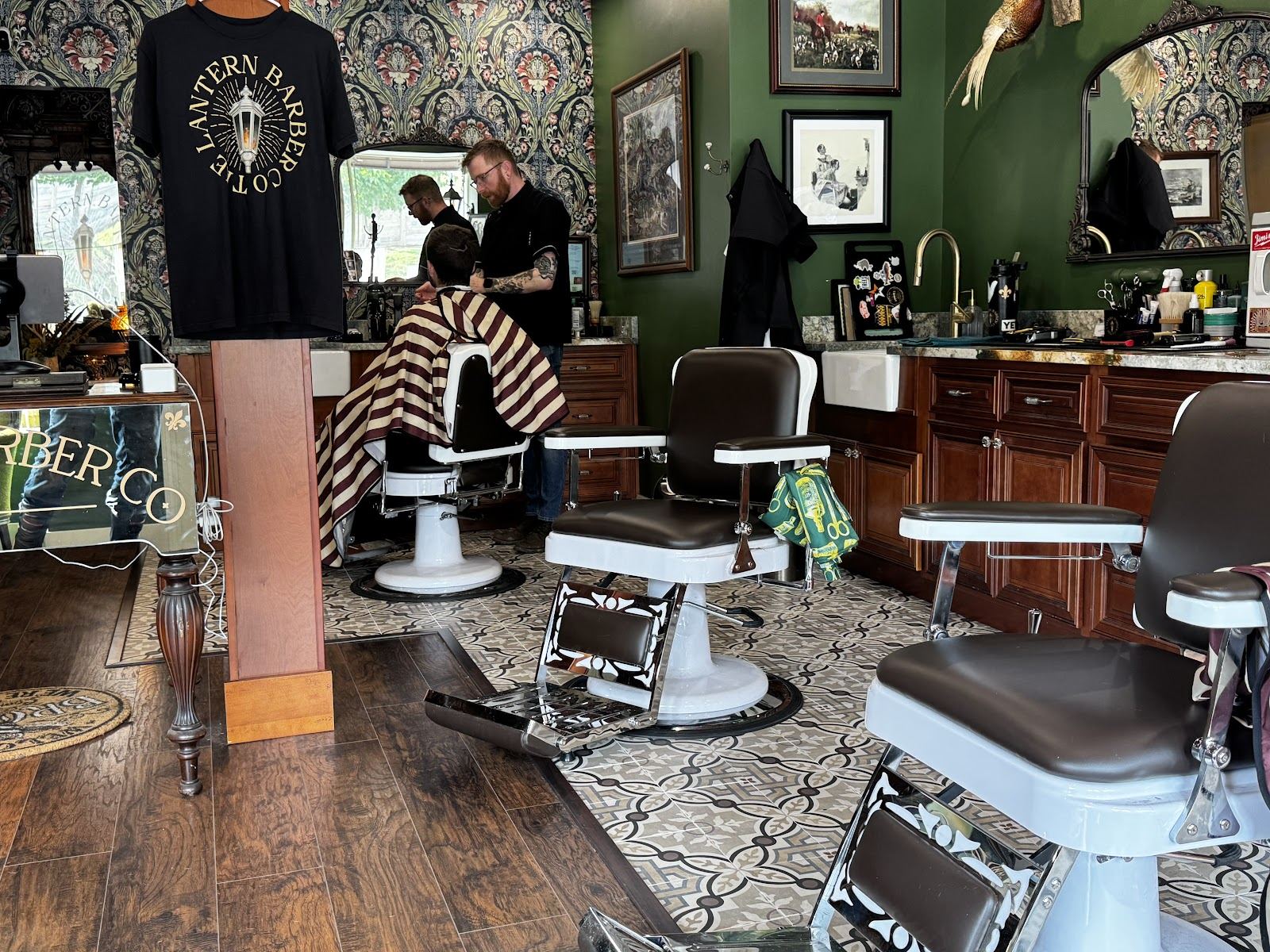 Inside The Lantern Barber Co., porcelain chairs and striped capes